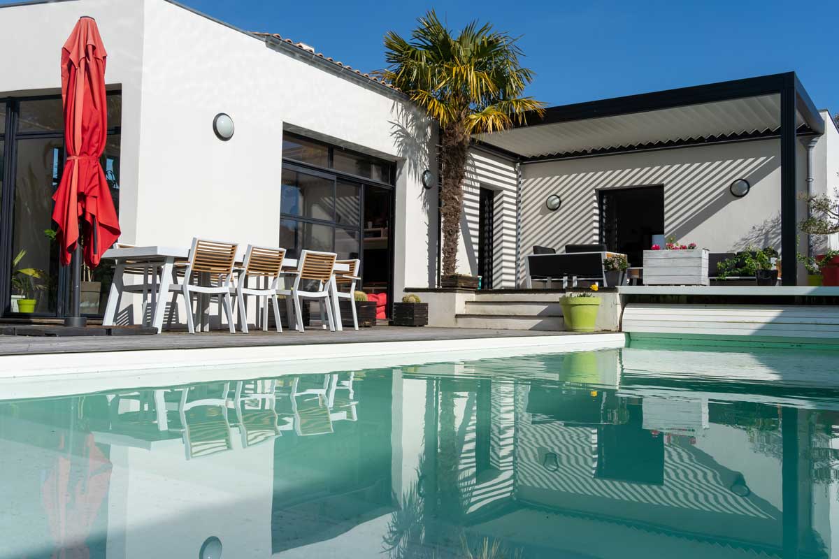 pool side with pergola, palm tree and red umbrella.